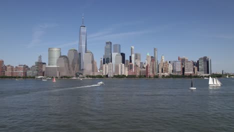 Luftaufnahme-über-Boote-Auf-Dem-Hudson-River,-In-Richtung-Der-Skyline-Von-Manhattan,-Im-Sonnigen-New-York,-USA---Niedrig,-Steigend,-Drohnenaufnahme