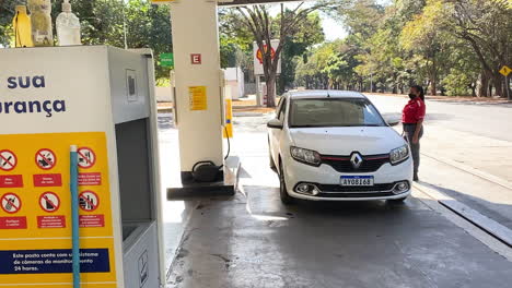 Das-Auto-Kommt-An-Einer-Tankstelle-An,-Der-Tankwart-Geht-Hinüber,-Um-Mit-Dem-Tanken-Zu-Beginnen