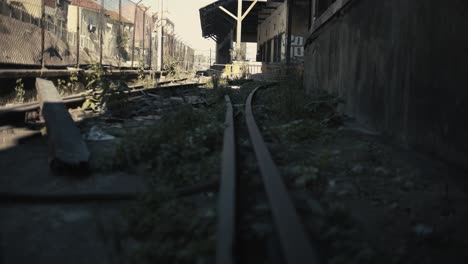 Abandoned-railway-with-old-warehouse-background-with-truck-camera-movement
