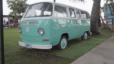 A-tilt-establishing-shot-of-a-beautifully-restored-iconic-VW-Van-parked-on-a-beach-in-Pattaya,-Chon-Buri,-Thailand