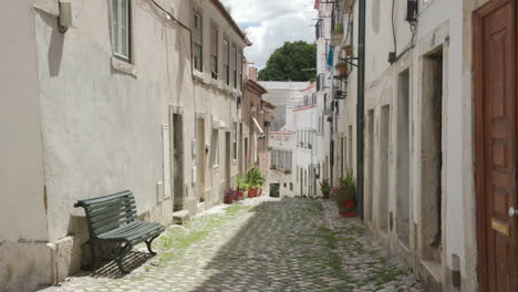 A-quiet-narrow-alleyway-in-Alfama,-one-of-the-oldest-neighborhoods-in-Lisbon,-Portugal