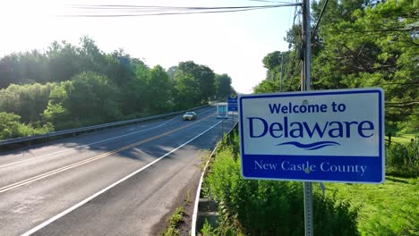 New-Castle-County,-Welcome-to-Delaware-sign-along-road-during-morning-sunshine-in-summer