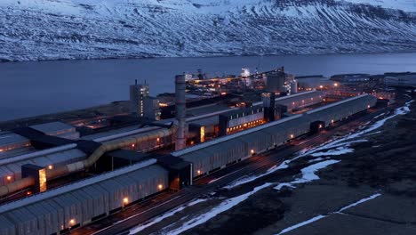 Night-time-at-big-industrial-facility-producing-aluminium-metal,-Iceland,-aerail