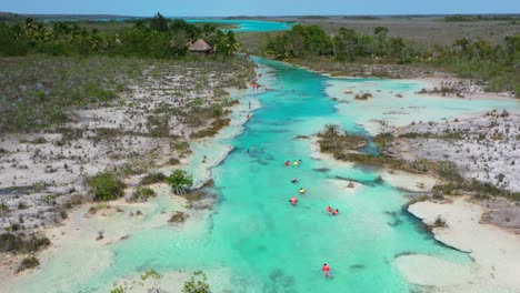 Turistas-Flotando-Por-El-Azul-Tropical-Los-Rápidos-En-Bacalar-México-En-Un-Día-Soleado,-Antena