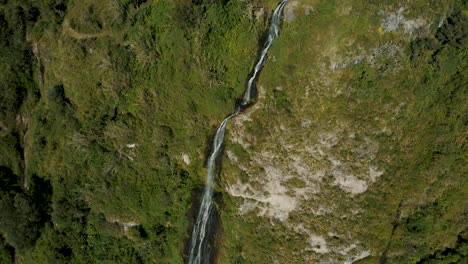 Aerial-Drone-View-Of-Impressive-Virgin-Waterfalls-Cascading-On-Rocky-Forest-Mountains-In-Baños,-Ecuador