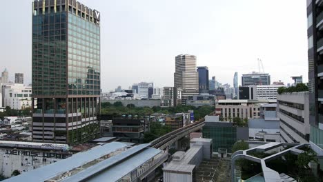 Cityscape-view-of-BTS-trains-passing-near-in-front-of-Asia-Hotel-in-Bangkok,-Thailand,-Southeast-Asia