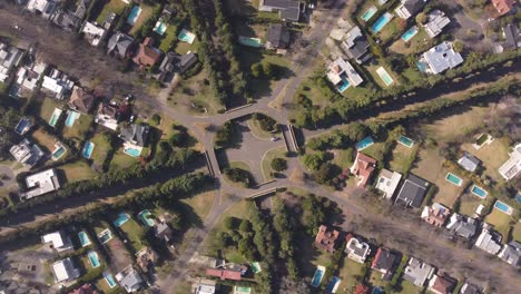 Aerial-top-down-ascending-circling-view-over-symmetric-residential-area-with-roundabout-and-houses-in-Buenos-Aires,-Argentina
