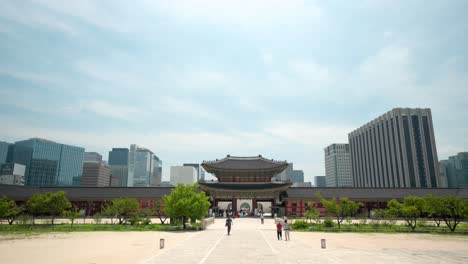 Puerta-Heungnyemun-Del-Palacio-Gyeongbokgung-Contra-El-Cielo-Azul-Con-Rascacielos-En-Segundo-Plano