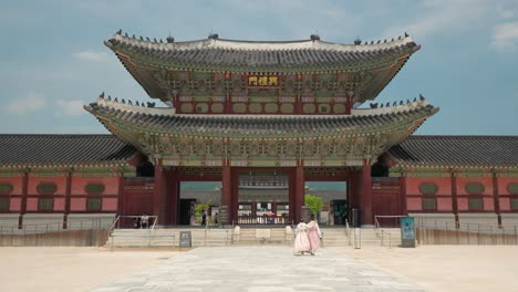 Rückansicht-Eines-Koreanischen-Paares-In-Rosa-Hanbok-Kleidung,-Das-Das-Heungnyemun-Tor-Betritt-Und-Im-Gyeongbokgung-Palast-Reist