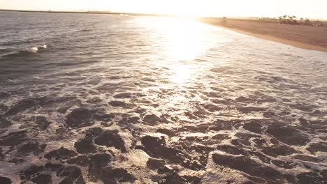 Drone-footage-of-Seal-Beach-in-Orange-County-California-with-ocean-waves-crashing-into-the-sand