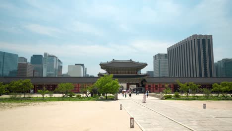 Heungnyemun-Gate-and-Yeongjegyo-bridge-at-Gyeongbokgung-Palace-with-a-view-of-Government-Seoul-Building-and-skyscrapers-against-blue-sky---copy-space
