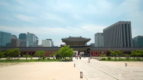 Puerta-Heungnyemun-Y-Puente-Yeongjegyo-En-El-Palacio-Gyeongbokgung-Con-Vistas-Al-Edificio-Del-Gobierno-De-Seúl-Y-Rascacielos-Contra-El-Cielo-Azul---Espacio-De-Copia