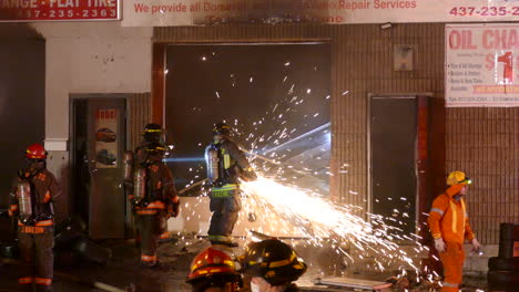 Mitarbeiter-Des-Toronto-Kanada-Feuerwehrteams-Zermahlen-Nachts-Trümmer-Vom-Tor-Der-Autowerkstatt