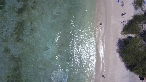 Im-Wasser-Sitzen-Und-Die-Wellen-Genießen.-Herrliche-Luftaufnahme,-Flug-Aus-Der-Vogelperspektive,-Drohnenaufnahmen-Von-Gili-T-Beach-Bali-Im-Sonnigen-Sommer-2017