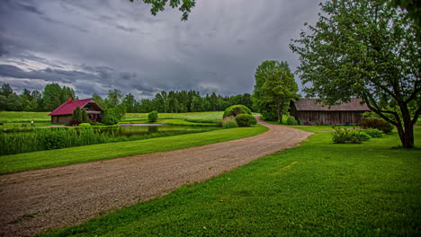 Scenic-countryside-time-lapse-with-two-houses-and-a-dramatic,-stormy-sky