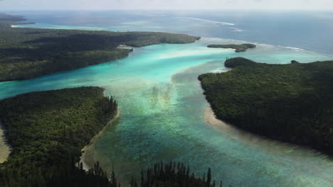 The-turquoise-water-of-the-Isle-of-Pines-at-Oro's-Bay-in-an-aerial-flyover-towards-the-open-Pacific-Ocean