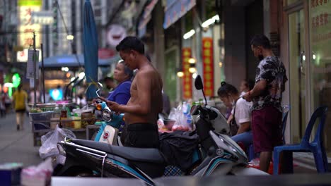 Hombre-Sin-Camisa-Hablando-Por-Teléfono-En-El-Barrio-Chino-De-Bangkok