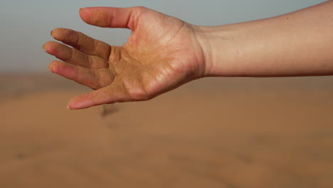 Mädchen-Gießt-Sand-Aus-Der-Hand-In-Der-Wüste-Von-Dubai