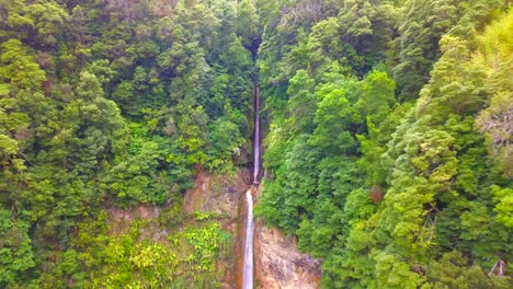 Aerial-4K-footage-of-a-huge-wild-waterfall-in-a-green-environment,-near-Ponta-Delgada-in-Sao-Miguel,-Azores-Islands