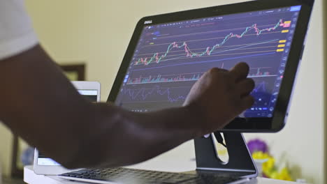 Hombre-Deslizando-Gráficos-Bursátiles-Mientras-Negocia-Día-En-Su-Computadora-Con-Pantalla-Táctil-En-El-área-De-Su-Oficina-En-Casa-Trabajando-Desde-Casa