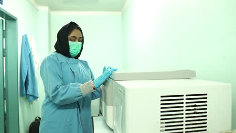 Muslim-Female-Nurse-Closing-Lid-On-Centrifuge-And-Providing-Thumbs-Up
