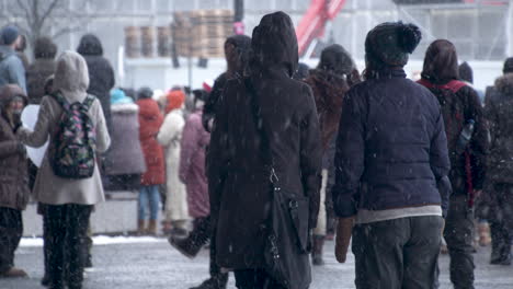 Medium-wide-shot-of-a-group-of-protesters-dancing-in-Helsinki's-Citizen-Square,-grey-winter-daylight