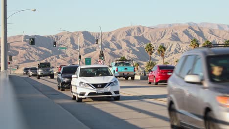 Traffic-on-Interstate-10-highway-in-California-and-barren-undulating-mountains