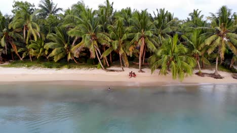 Children-waving-as-drone-flys-away-from-white-sandy-beach-in-Madagascar