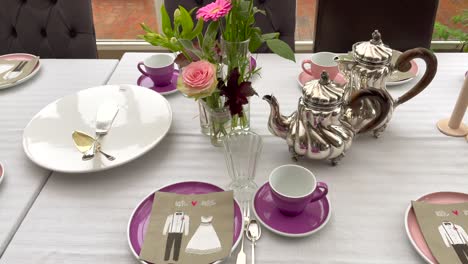 Close-truck-shot-of-laid-table-for-wedding-party-with-flowers-and-coffee-and-teapot