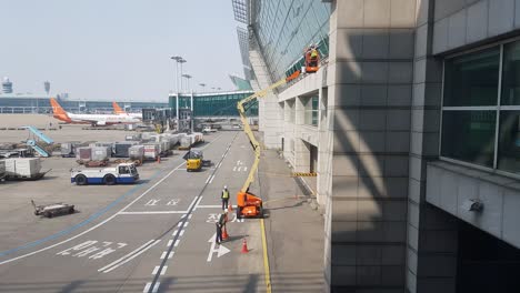 Reiniger-Auf-Hydraulischer-Gelenk-Fensterreinigungs-Lift-Plattform,-Waschen-Und-Wischen-Von-Glasfenstern-Am-Internationalen-Flughafen-Incheon