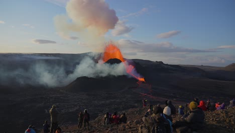 Menschen-Beobachten-Und-Filmen-Einen-Vulkanausbruch,-Bei-Dem-Heiße-Lava-Aus-Dem-Krater-In-Wallingadalir,-Island,-Explodiert