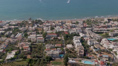 Coastal-Greek-town-of-Agia-Marina-in-Crete-island,-aerial-drone-view