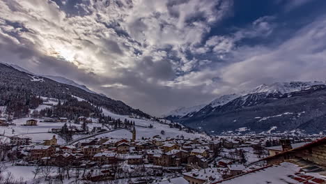 Time-lapse-shot-of-flying-clouds-over-snowy-Bormio-Village-during-sunny-day-in-winter---Italy,Europe