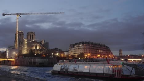 Tourist-barge-ship-sailing-during-the-afternoon-in-Seine-river-with-Notre-Dame-as-background