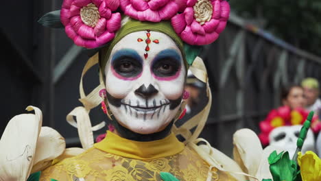 Close-up-shot-in-slow-motion-of-a-woman-at-the-Day-of-The-Dead-Parade-in-Mexico-City,-wearing-a-traditional-outfit,-sugar-skull-makeup-and-flower-headpiece