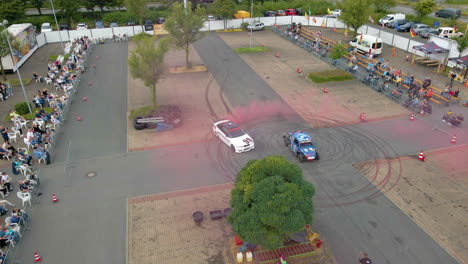 Spectators-Watching-A-Drifting-Car-With-Red-Smoke-From-Exhaust-At-A-Stunt-Show-And-Exhibition