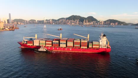 Large-Container-Ship-leaving-Hong-Kong-bay-under-Stonecutters-bridge,-Aerial-view