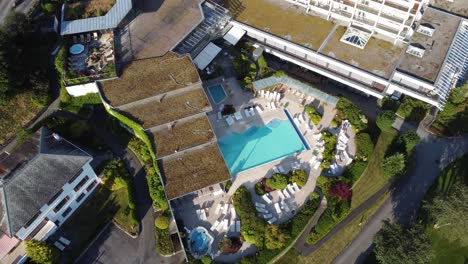 Swimming-pool-with-garden-and-outdoor-recreational-area-at-hotel-Alexandra-Loen---Upward-moving-aerial-with-tilt-down---Norway