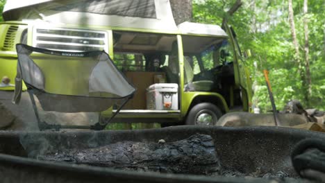 Volkswagen-Bus-Autocaravana-Anillo-De-Fuego-Humeante-Campamento-Silla-Bosque-Verde-Camara-Lenta-Mano