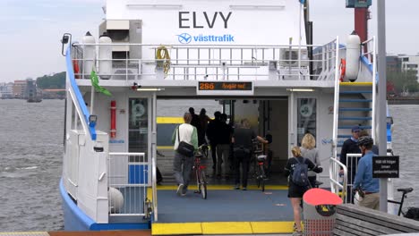 Passengers-boarding-on-Elvy-Västtrafik-electric-hybrid-ferry-at-Gothenburg-Sweden---Covid-19-normal-life
