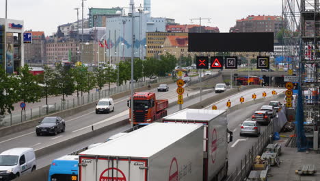 Daytime-Traffic-At-E45-Gotaleden-In-Gothenburg,-Sweden-With-Distant-View-Of-Goteborg-Energi-Rosenlundsverket-Power-Station