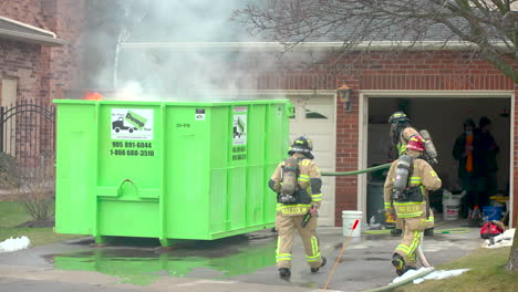 A-fire-truck-drives-by-as-firefighters-respond-at-the-scene-of-a-flaming-dumpster-fire