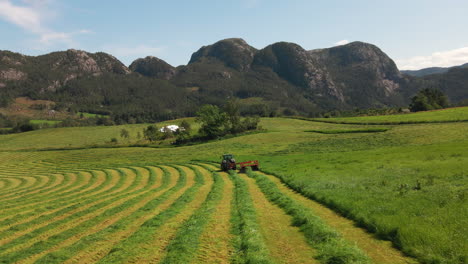 A-tractor-cutting-grass-for-harvest-in-a-field-on-a-rural-mountain-farm