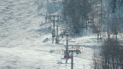 Tourists-Ride-Upwards-At-The-Ski-Lifts-Inside-The-Mountain-Resort-In-Okuhida-Hirayu,-Takayama-City,-Japan