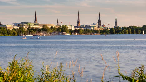 Beautiful-time-lapse-of-Außenalster-with-skyline-and-boats-passing-by-on-sunny-day-in-Hamburg,-Germany