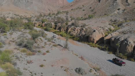 SUV's-Driving-Along-Dry-Desert-Ravine-In-Balochistan