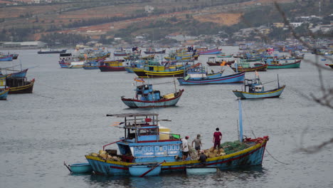 Local-fishing-boats-and-fishermen-at-sea-in-the-town-of-Mui-Ne,-Vietnam