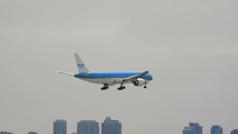 Incoming-KLM-Flight-landing-at-Pearson-International-Airport-passing-clouds-and-city-skyline-of-Toronto