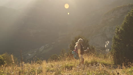 Blonde-woman-hiking-at-sunset-in-the-mountains-of-Benasque,-Spain,-wide-shot