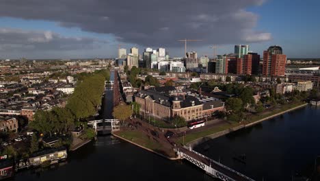 Aerial-view-and-approach-of-Muntgebouw-museum-in-Utrecht-with-small-draw-bridge-over-the-canal-in-front-on-a-bright-sunny-day-with-cloud-formation-in-the-background